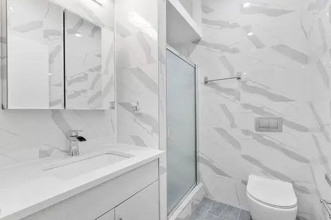 a bathroom with a sink a toilet and shower