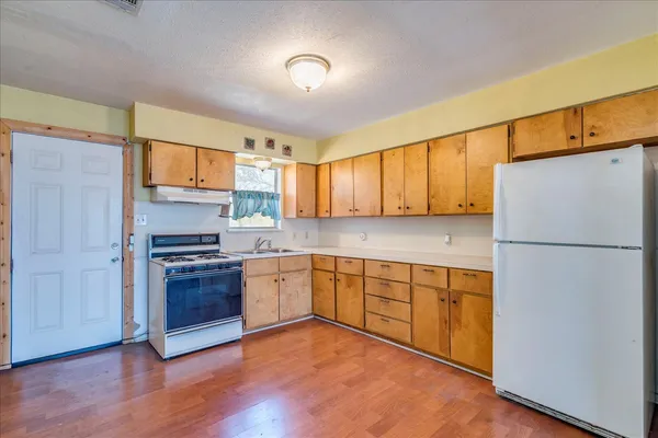 a kitchen with stainless steel appliances granite countertop a stove a sink and a refrigerator
