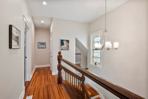 a view of a hallway with wooden floor and staircase