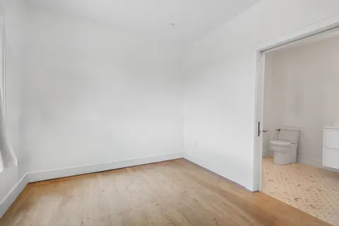 a view of a room with wooden floor and a sink