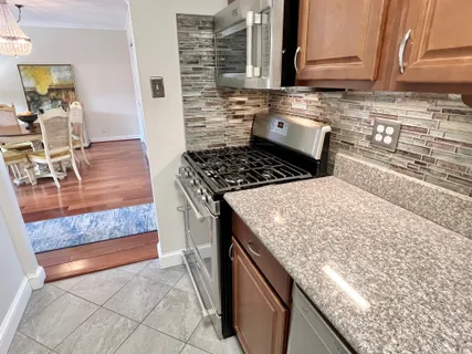 a kitchen with granite countertop a stove a oven and a counter space