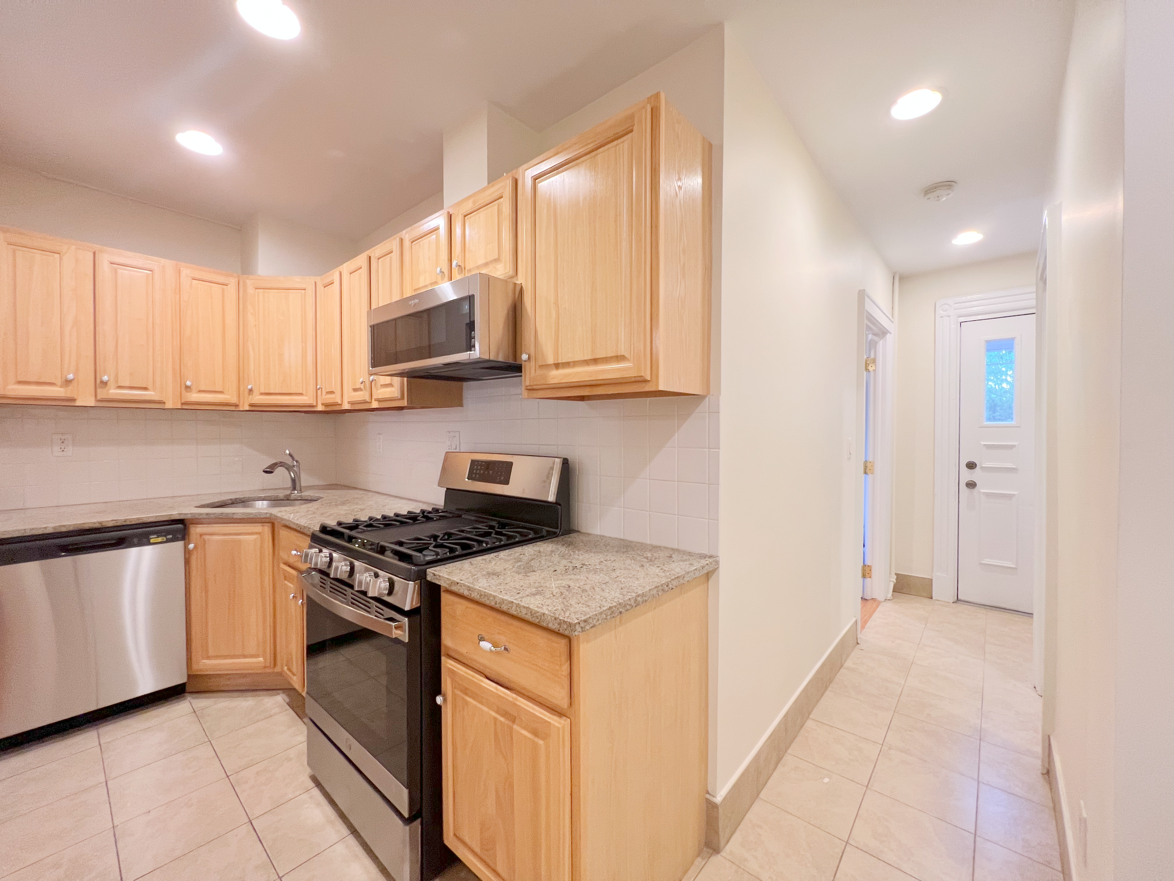 651 10th Street, Unit 1 Brooklyn, NY 11215 - Photo 7 of 12 a kitchen with stainless steel appliances granite countertop a stove a sink and a microwave