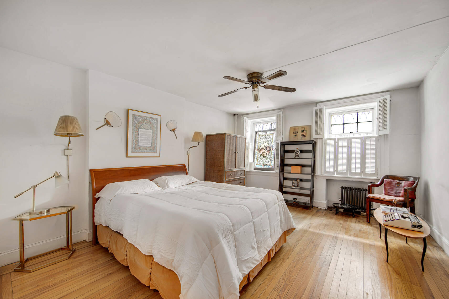 337 East 18th Street Manhattan, NY 10003 - Photo 7 of 16 a bedroom with a bed a dresser and wooden floor