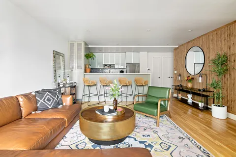 a living room with furniture a rug and a large window