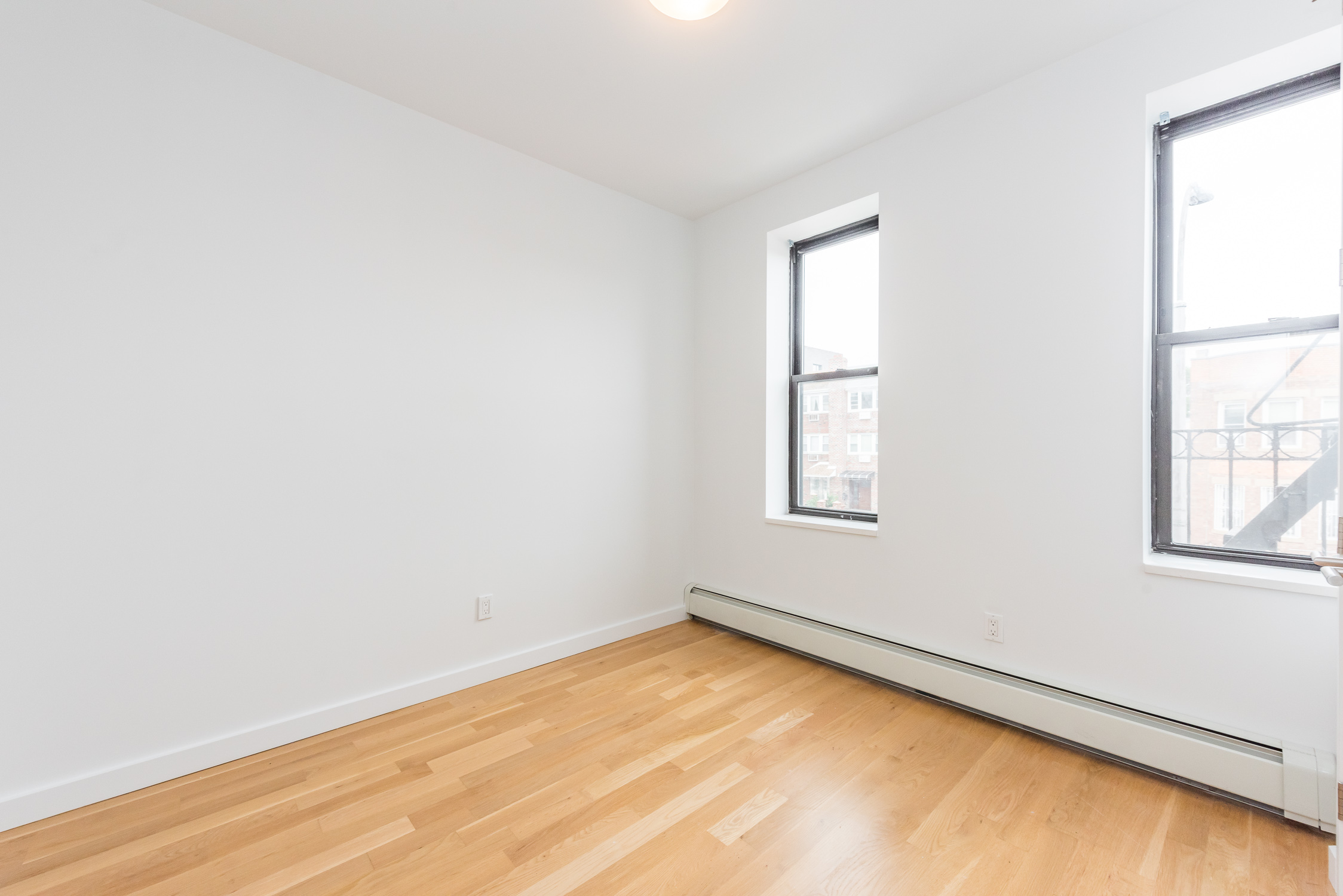 22-11 Steinway Street, Unit 3R Queens, NY 11105 - Photo 8 of 9 an empty room with windows