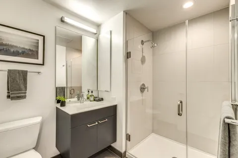 a bathroom with a double vanity sink mirror and toilet