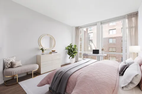 a bedroom with a bed and a large mirror with wooden floor