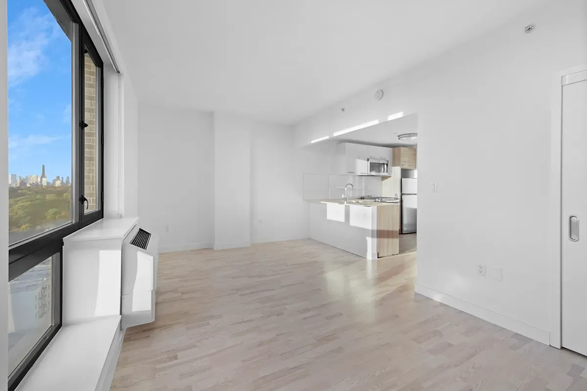 a view of empty room with wooden floor and window