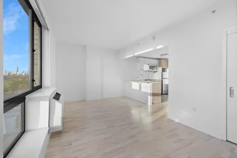 a view of empty room with wooden floor and window