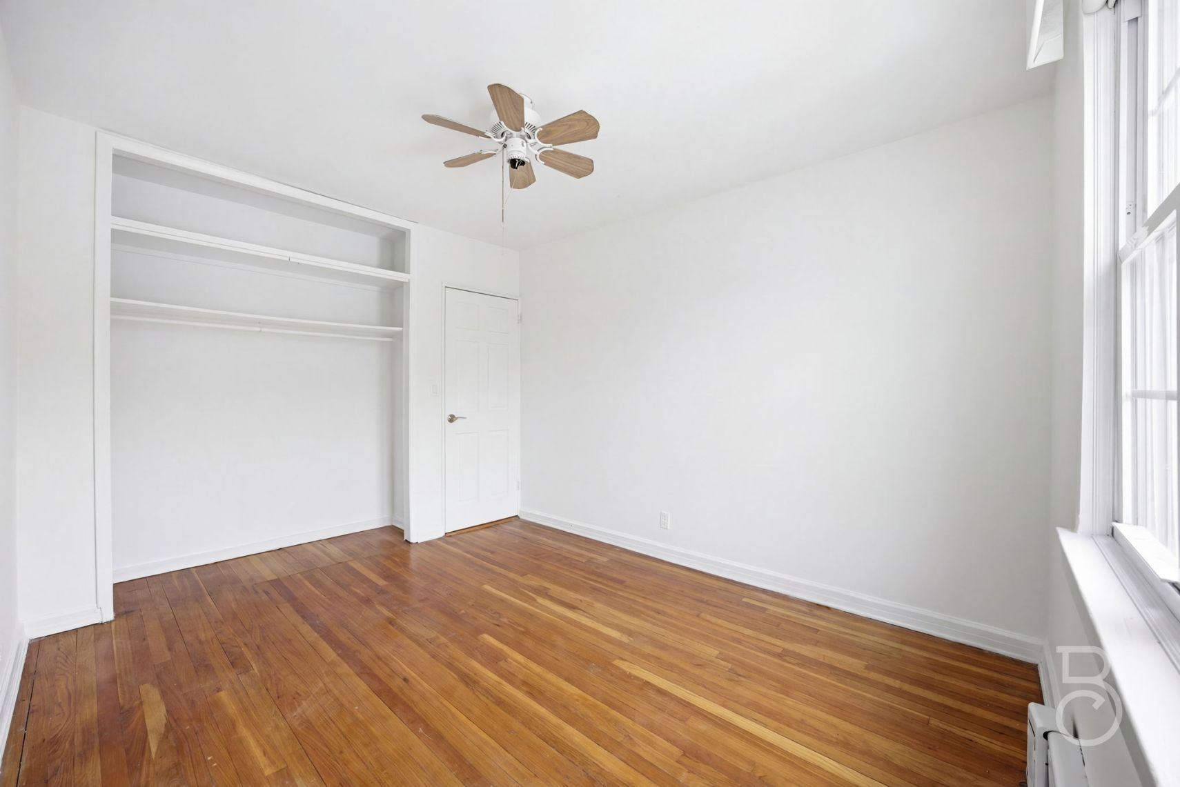 22-61 46th Street Queens, NY 11105 - Photo 20 of 24 a view of empty room with wooden floor and fan