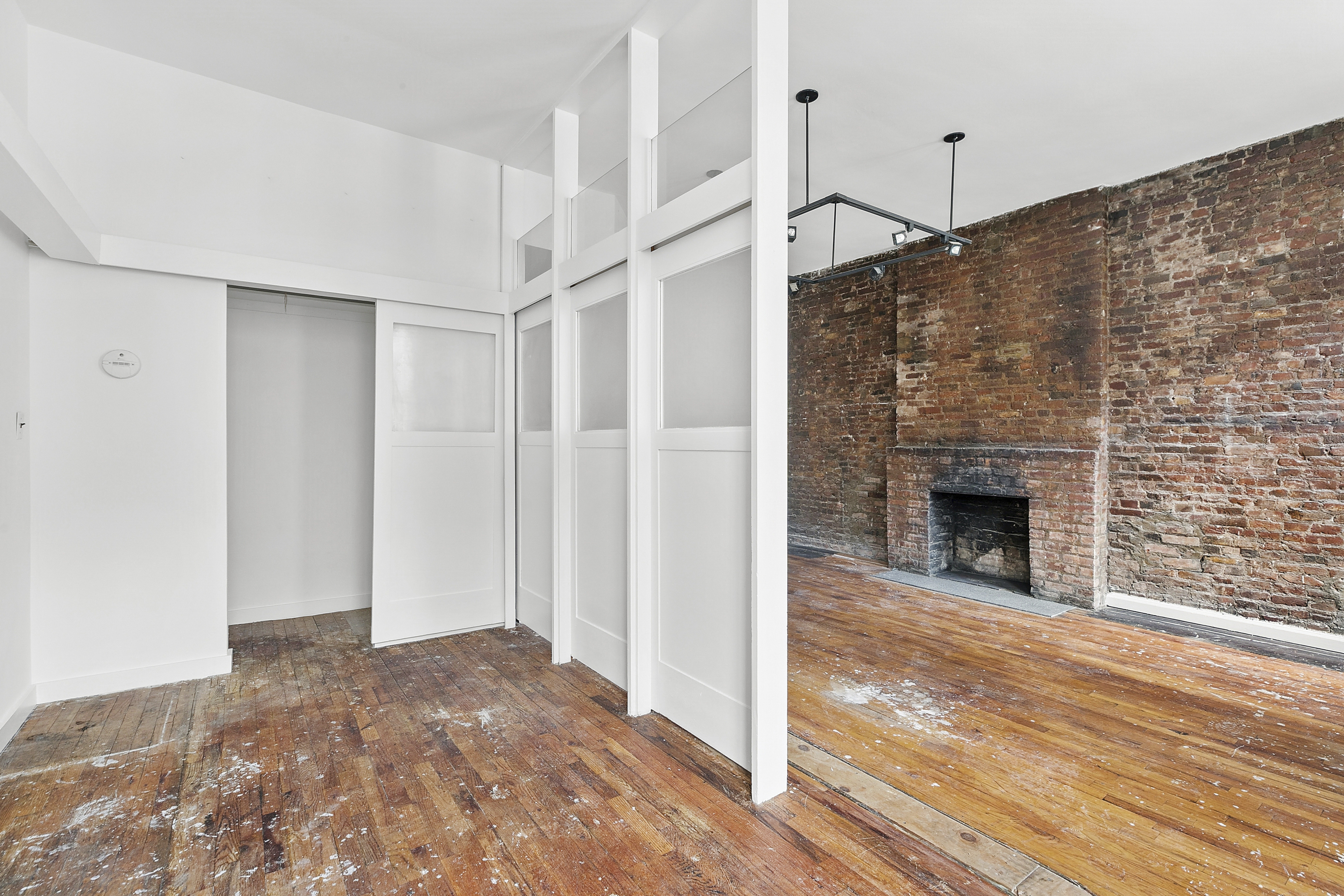 360 West 20th Street, Unit 2F Manhattan, NY 10011 - Photo 5 of 7 a view of a livingroom with wooden floor a fireplace and entryway