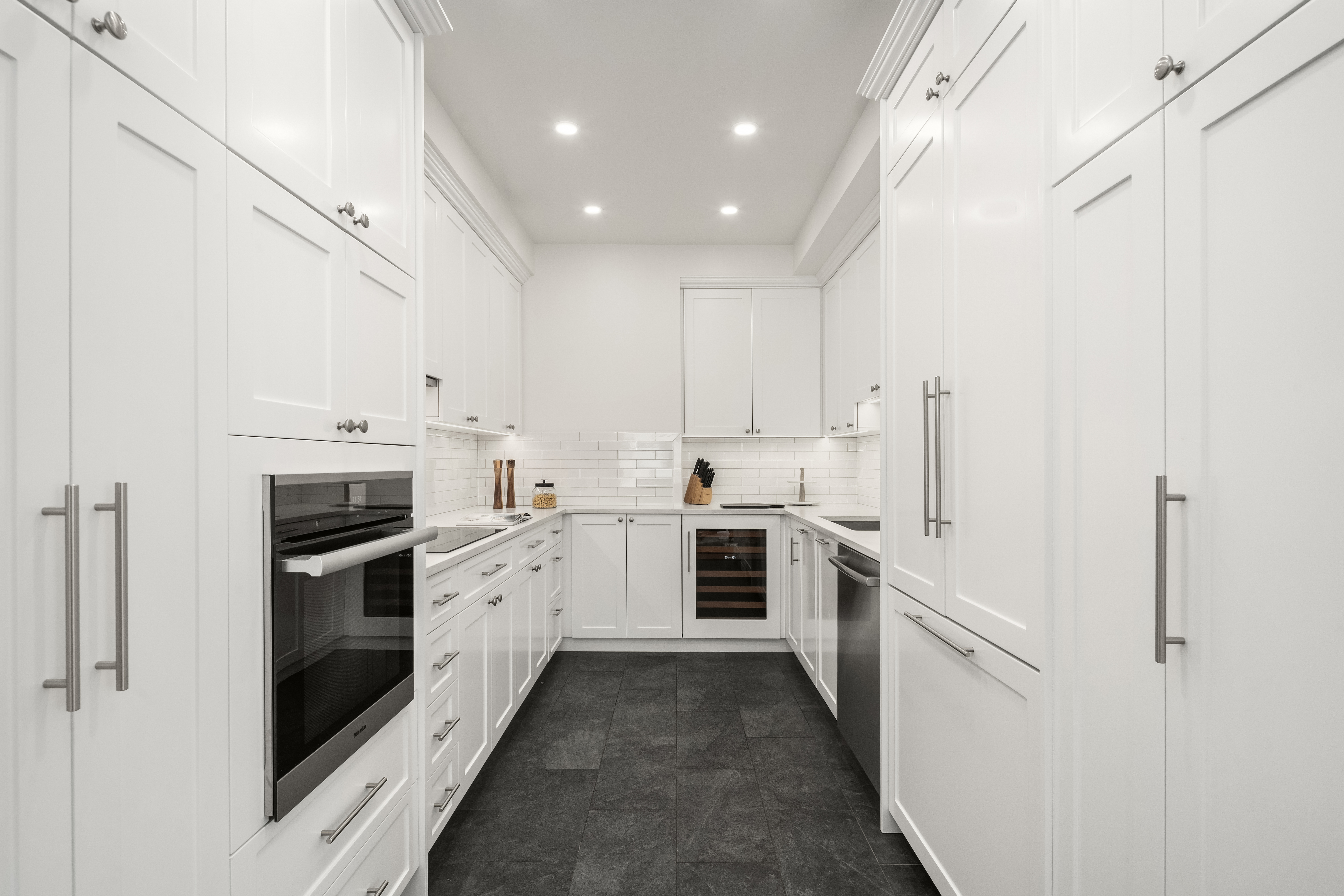 23 West 73rd Street, Unit 1001 Manhattan, NY 10023 - Photo 6 of 14 a kitchen with white cabinets and stainless steel appliances