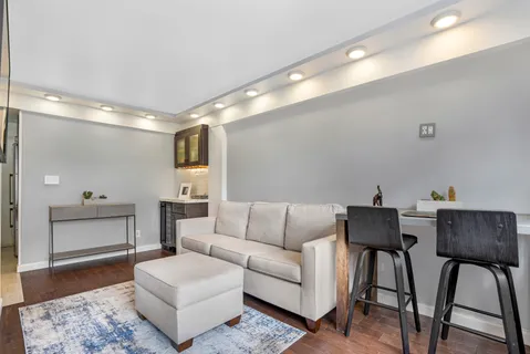 a living room with furniture and a wooden floor