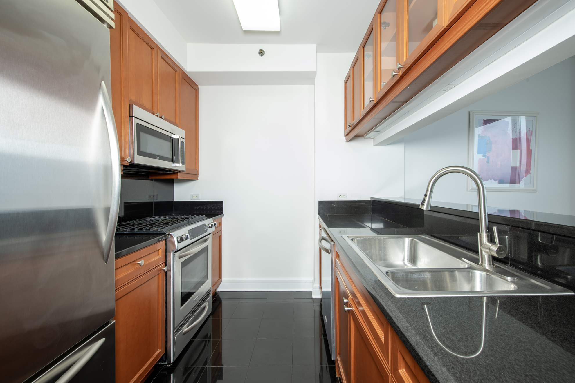 220 Riverside Boulevard, Unit 9K Manhattan, NY 10069 - Photo 3 of 8 a kitchen with stainless steel appliances granite countertop a sink and a stove