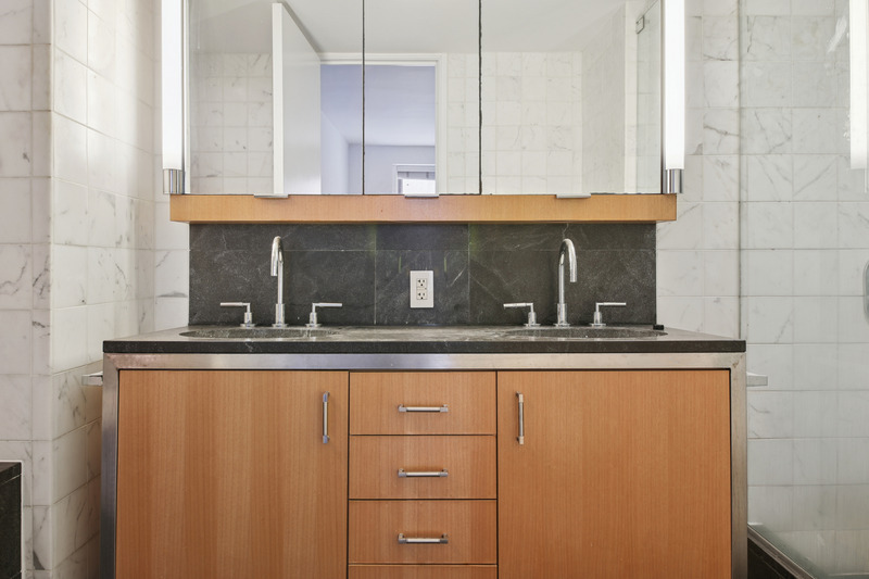 100 West 58th Street, Unit 5E Manhattan, NY 10019 - Photo 7 of 12 a bathroom with a sink and mirror