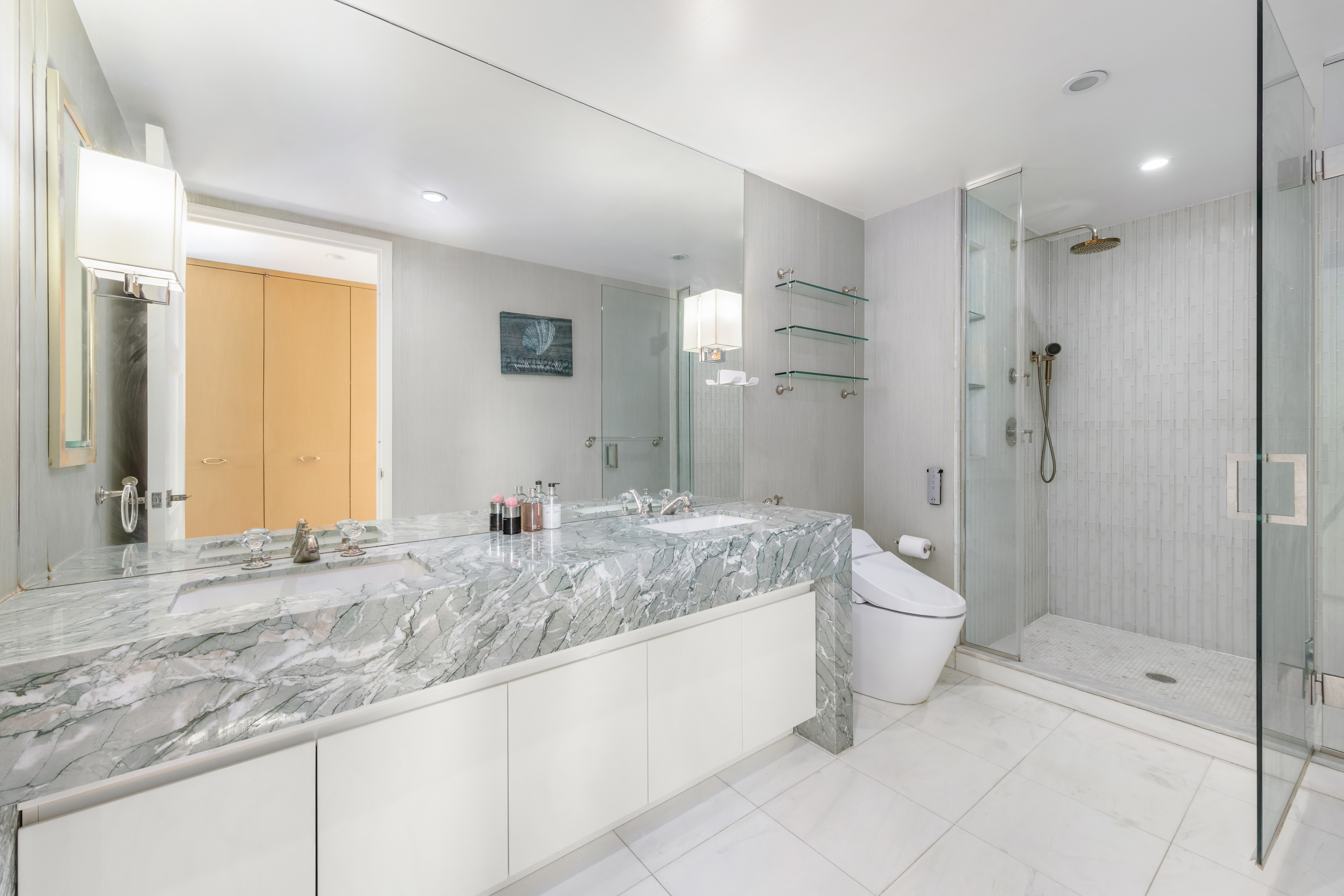 305 East 85th Street, Unit 14D Manhattan, NY 10028 - Photo 7 of 11 a bathroom with a granite countertop sink mirror vanity and toilet