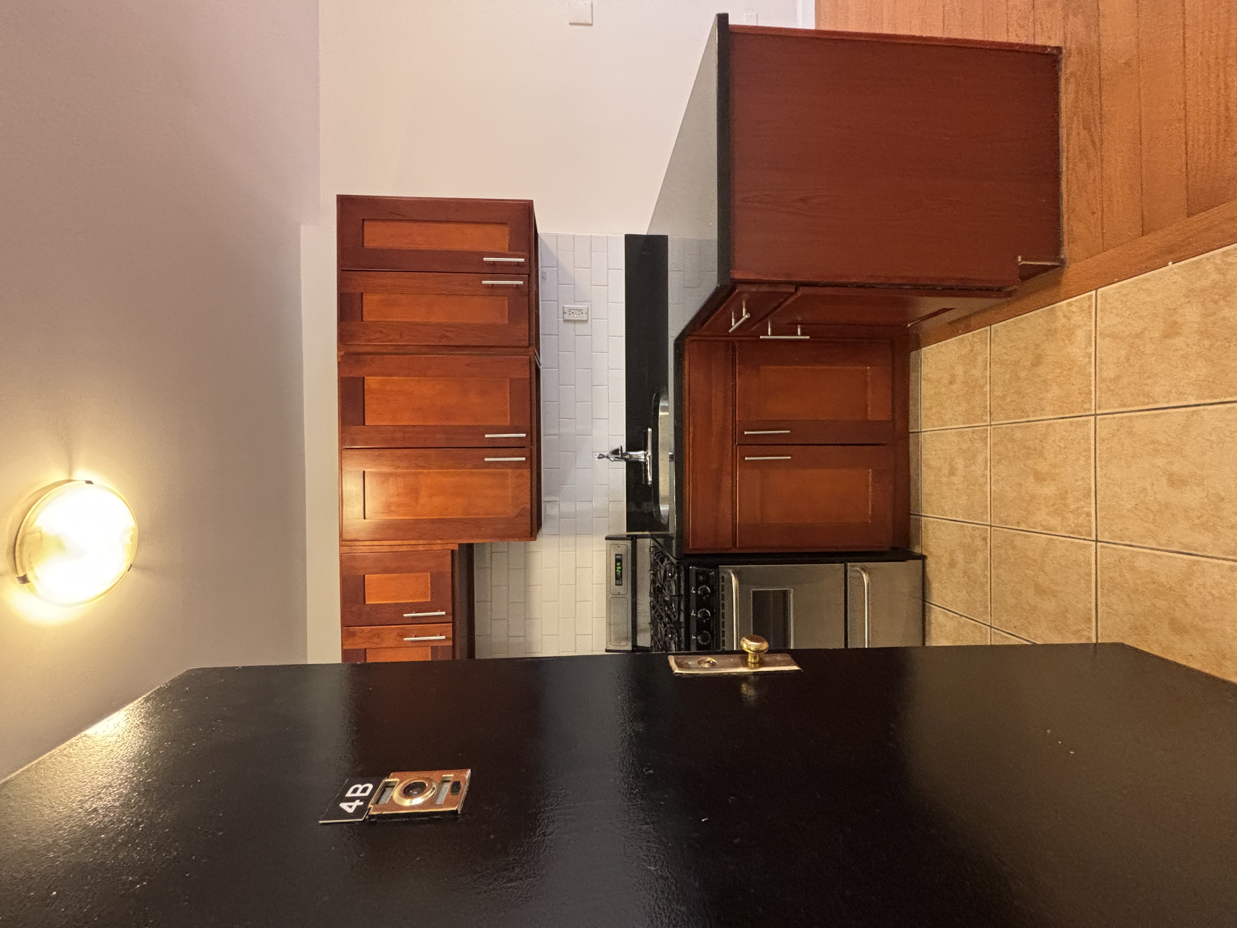 99 St Marks Place, Unit 4B Manhattan, NY 10009 - Photo 8 of 10 a kitchen with granite countertop a refrigerator and a stove top oven