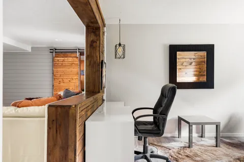 a view of a workspace with furniture and a window