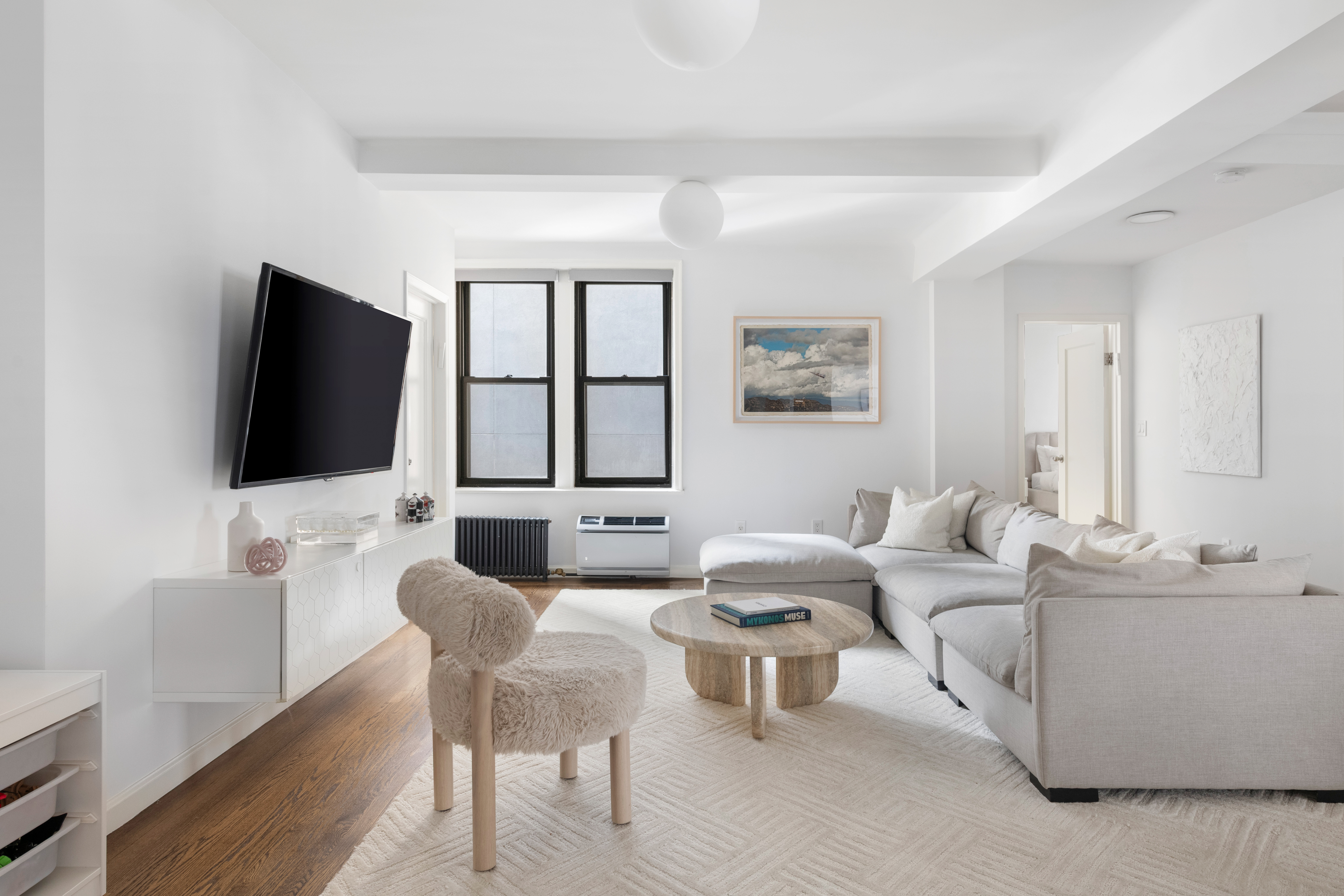 308 East 79th Street, Unit 13EF Manhattan, NY 10075 - Photo 5 of 16 a living room with furniture and a flat screen tv