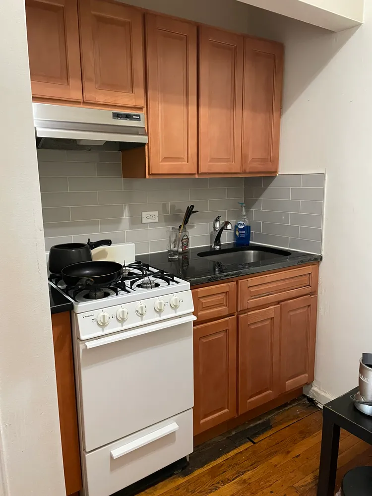 a kitchen with granite countertop a stove sink and cabinets