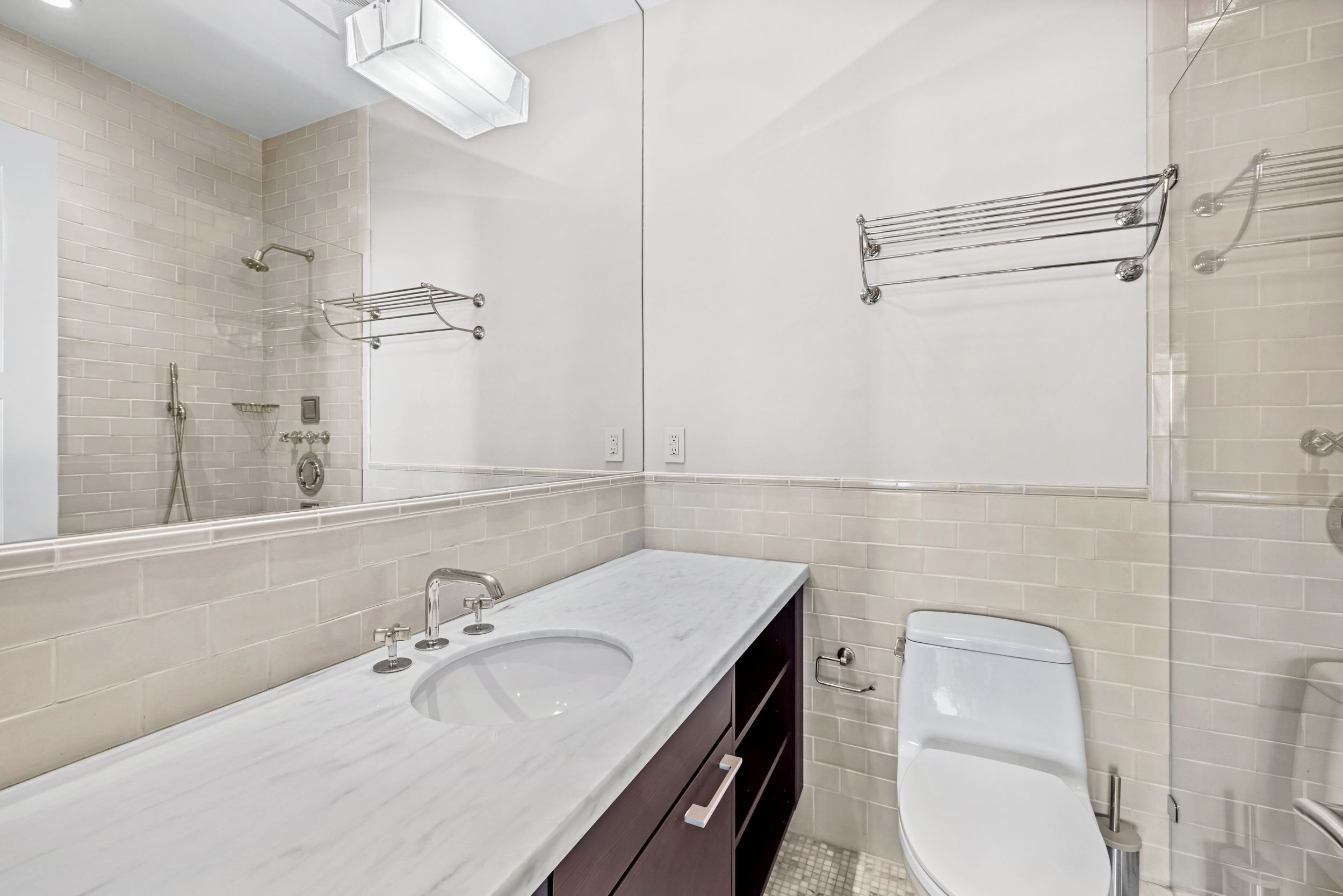 150 West 56th Street, Unit 4802 Manhattan, NY 10019 - Photo 8 of 13 a bathroom with a sink toilet and vanity