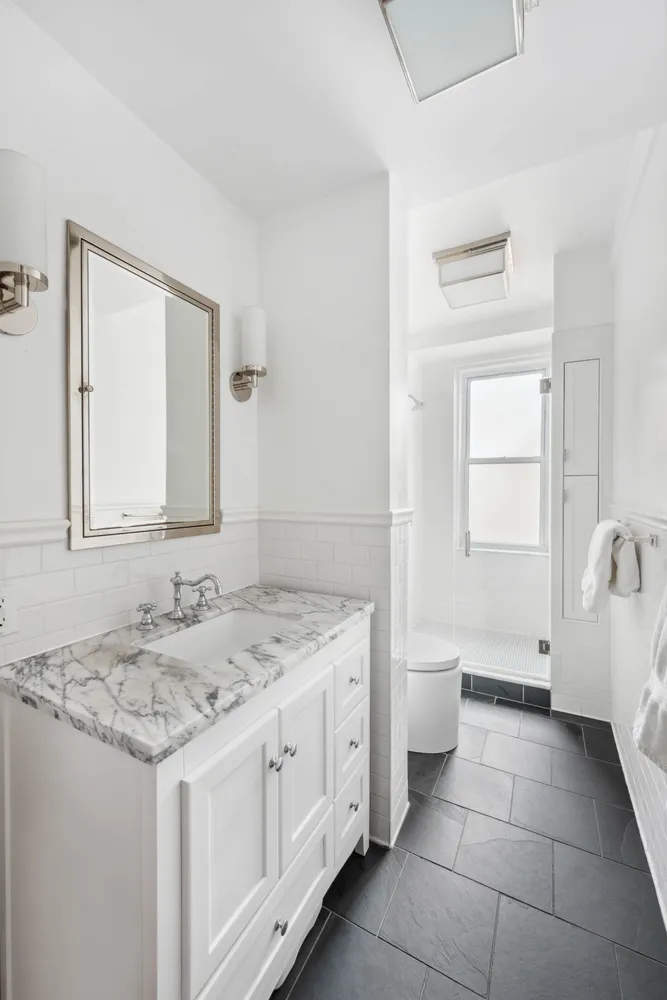 a spacious bathroom with a granite countertop sink a toilet and a mirror