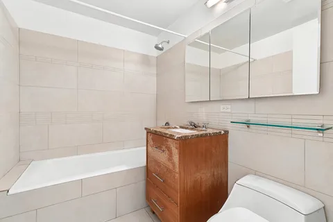 a bathroom with a tub sink and vanity