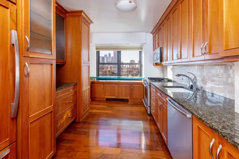 a kitchen with granite countertop a sink and wooden cabinets