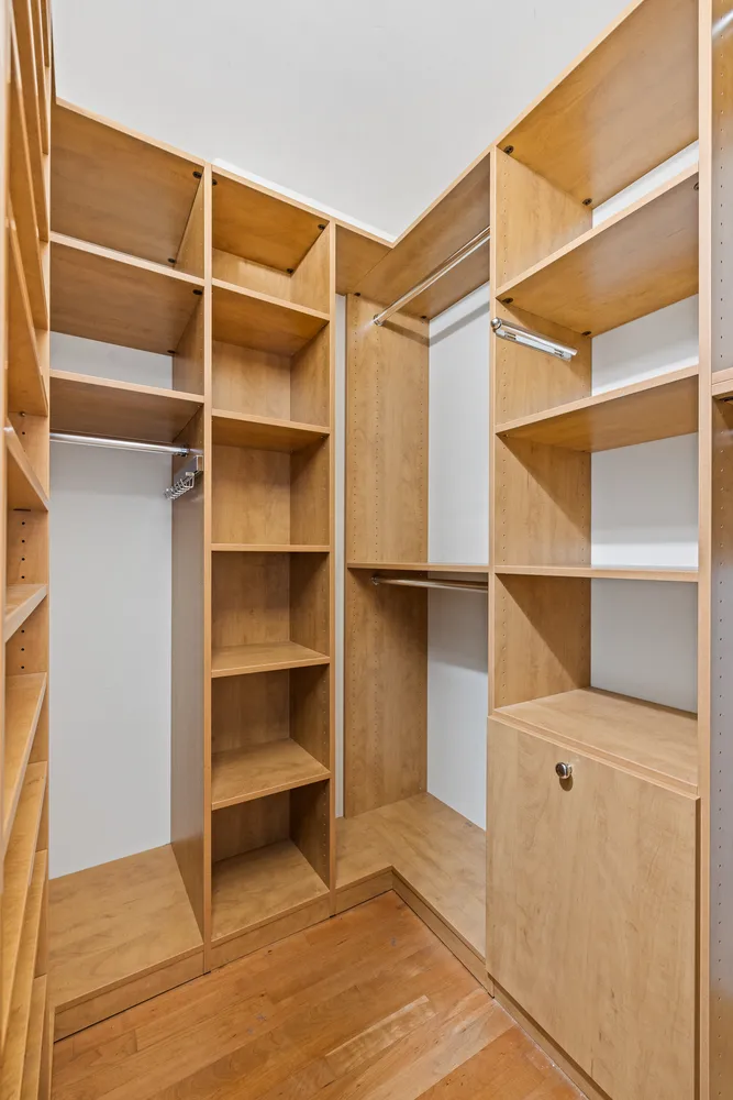 a view of walk in closet with empty racks