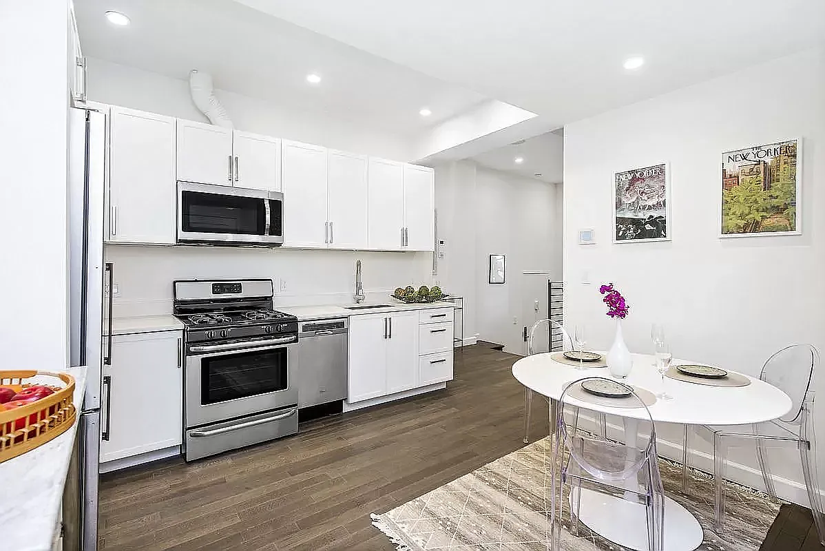 44 East End Avenue, Unit TH1 Manhattan, NY 10028 - Photo 5 of 14 a kitchen with a stove a microwave and a dining table