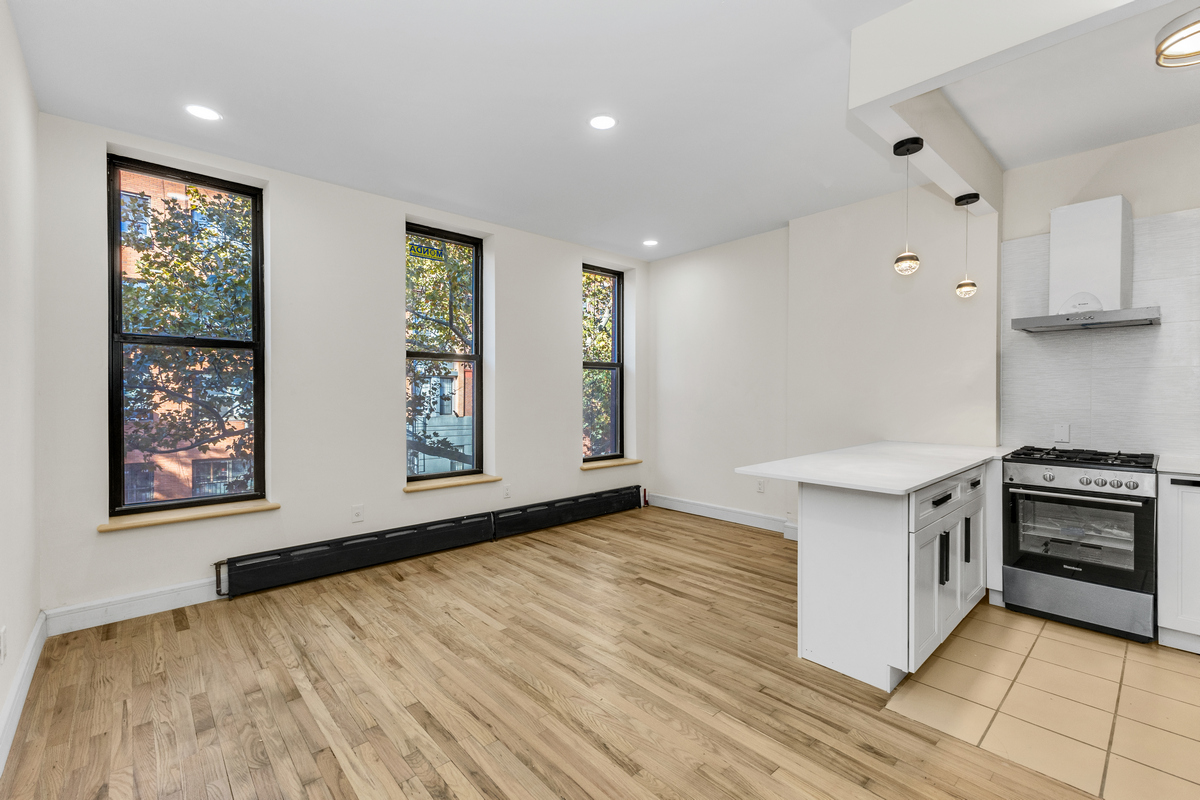 574 Gates Avenue Brooklyn, NY 11221 - Photo 2 of 16 a kitchen with stainless steel appliances granite countertop a stove and a refrigerator