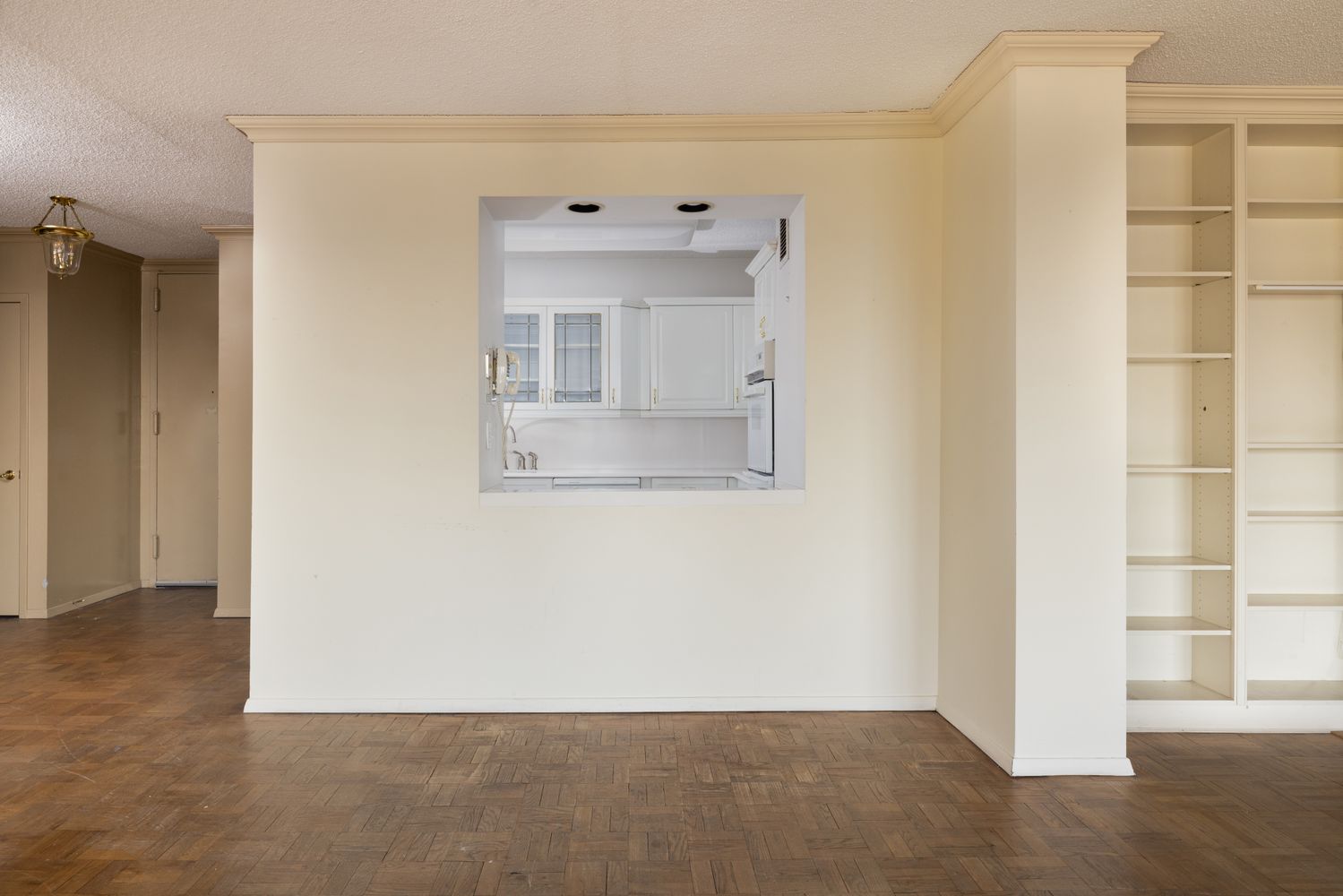 an empty room with a window and cabinet