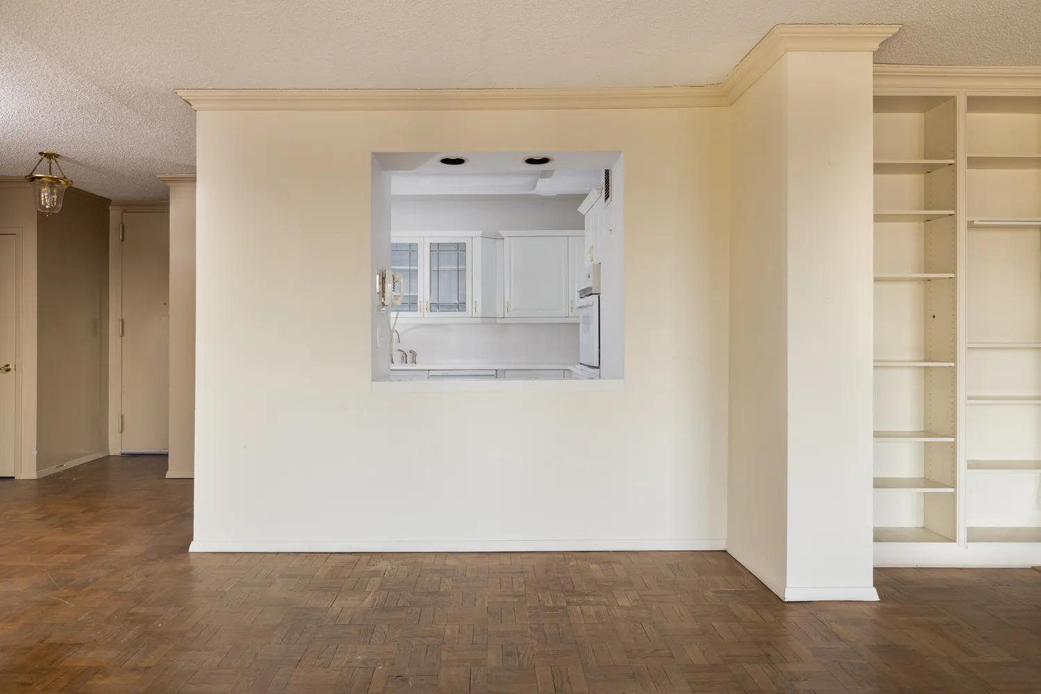 an empty room with a window and cabinet