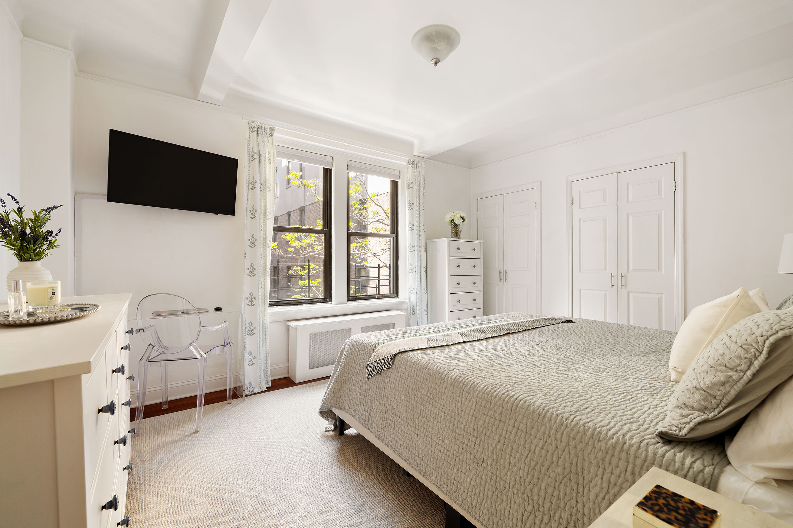 60 East 96th Street, Unit 6C Manhattan, NY 10128 - Photo 5 of 9 a spacious bedroom with a bed and a flat screen tv