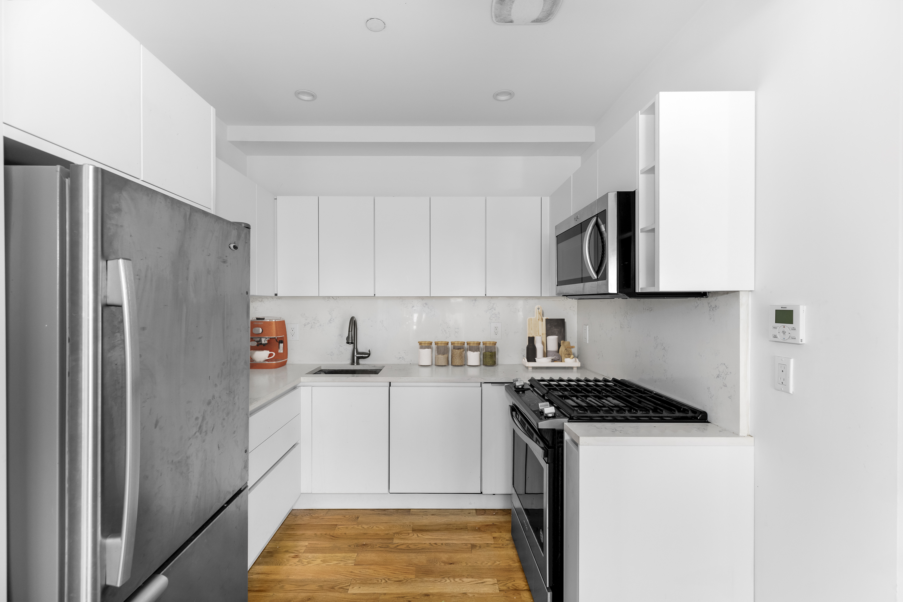 18 A Bleecker Street, Unit 1A Brooklyn, NY 11221 - Photo 3 of 6 a kitchen with stainless steel appliances granite countertop a refrigerator and a stove top oven