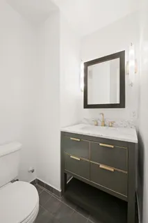 a bathroom with a toilet sink and mirror