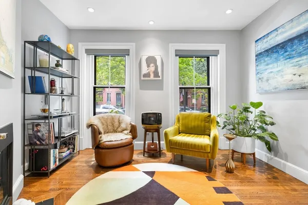 a living room with furniture fireplace and a large window