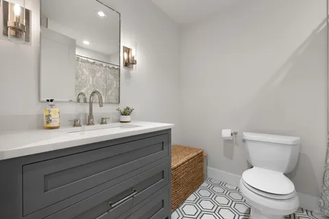 a bathroom with a toilet a sink and mirror