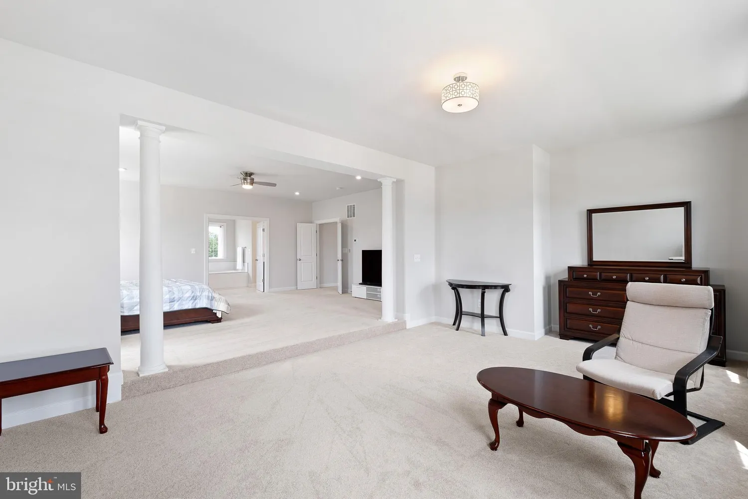 a spacious bedroom with a bed and a chandelier