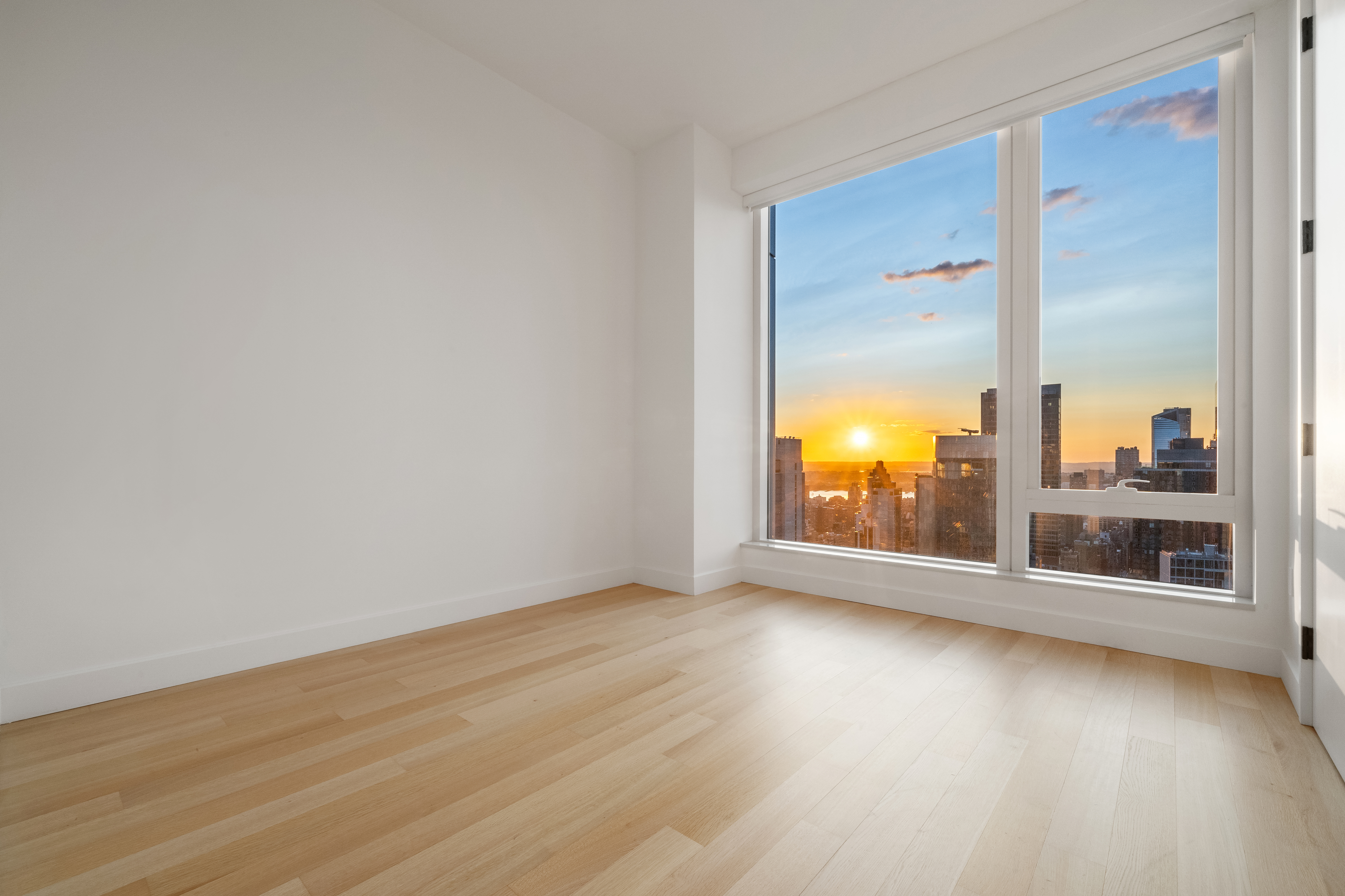 15 East 30th Street, Unit 42A Manhattan, NY 10016 - Photo 6 of 13 an empty room with wooden floor and windows