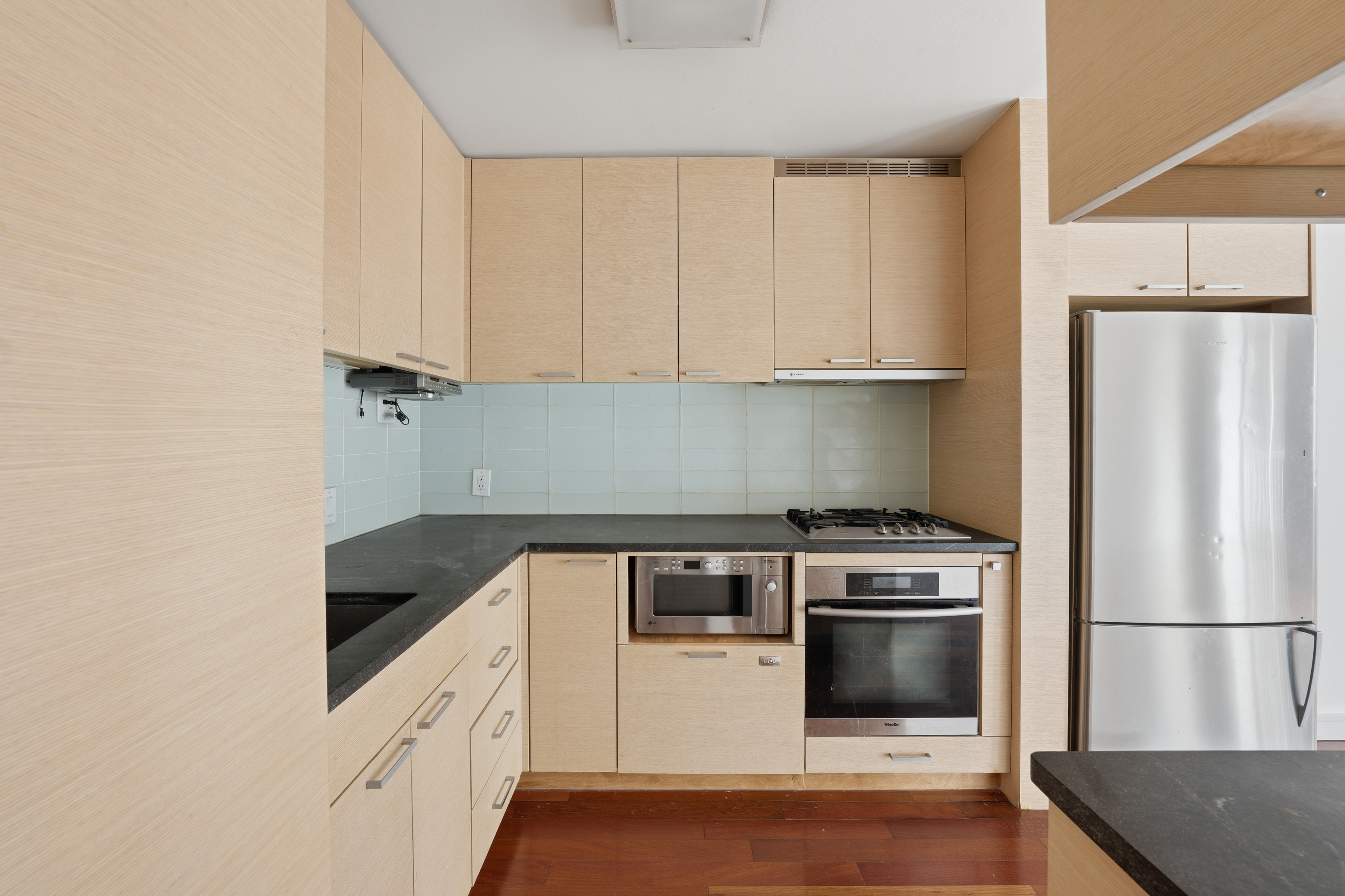 206 East 95th Street, Unit 6B Manhattan, NY 10128 - Photo 17 of 25 a kitchen with white cabinets and white appliances
