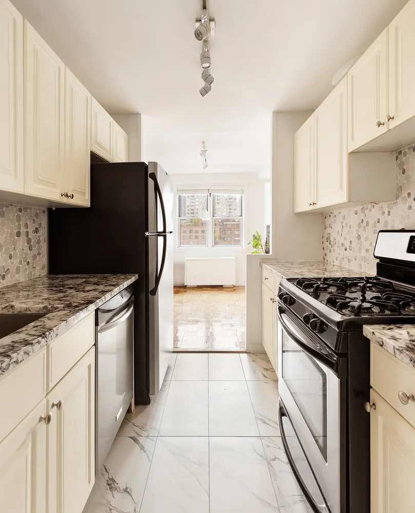 a kitchen with granite countertop a stove sink and cabinets