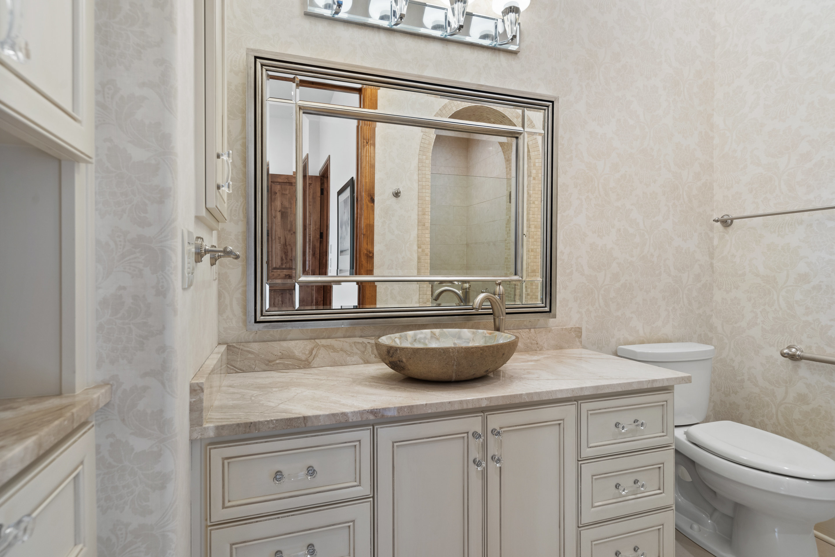 808 Rivercliff Drive Spicewood, TX 78669 - Photo 57 of 71 a bathroom with a granite countertop sink a toilet and mirror