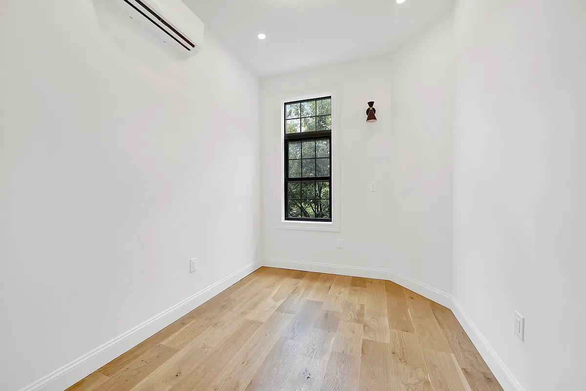 297 Howard Avenue, Unit 2 Brooklyn, NY 11233 - Photo 10 of 13 an empty room with a window and wooden floor