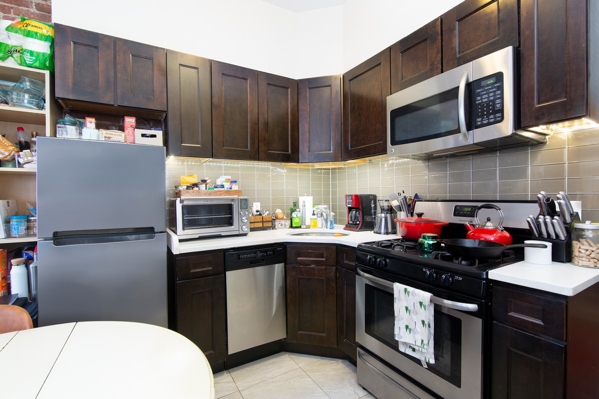 445 Rogers Avenue, Unit 1LF Brooklyn, NY 11225 - Photo 3 of 6 a kitchen with a sink a stove and cabinets