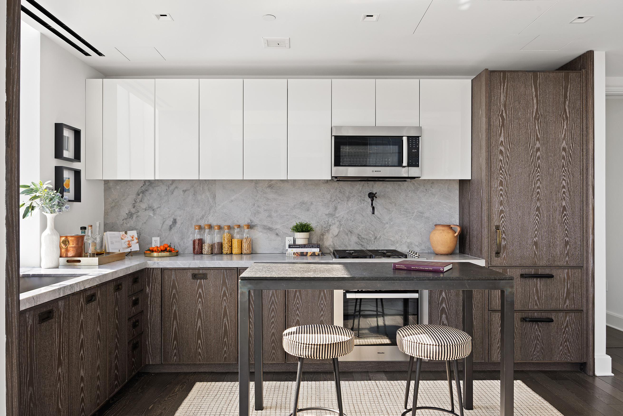 45 East 22nd Street, Unit 32B Manhattan, NY 10010 - Photo 11 of 36 a kitchen with stainless steel appliances a stove a sink cabinets and a dining table