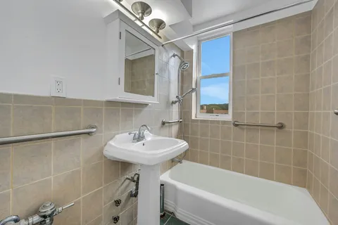 a bathroom with a sink a mirror toilet and bathtub
