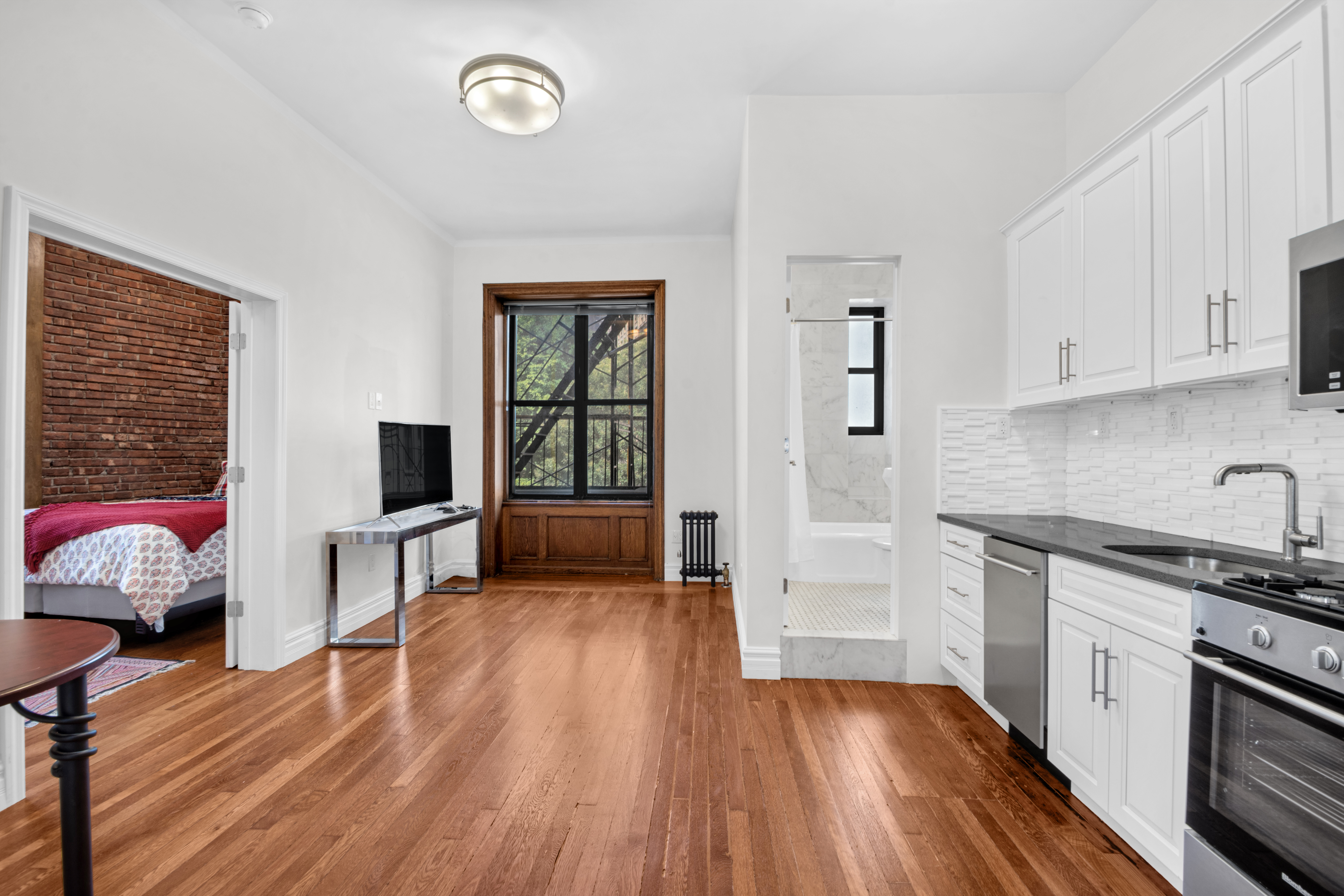 244 Riverside Drive, Unit 2F Manhattan, NY 10025 - Photo 3 of 8 a kitchen with furniture and a wooden floor