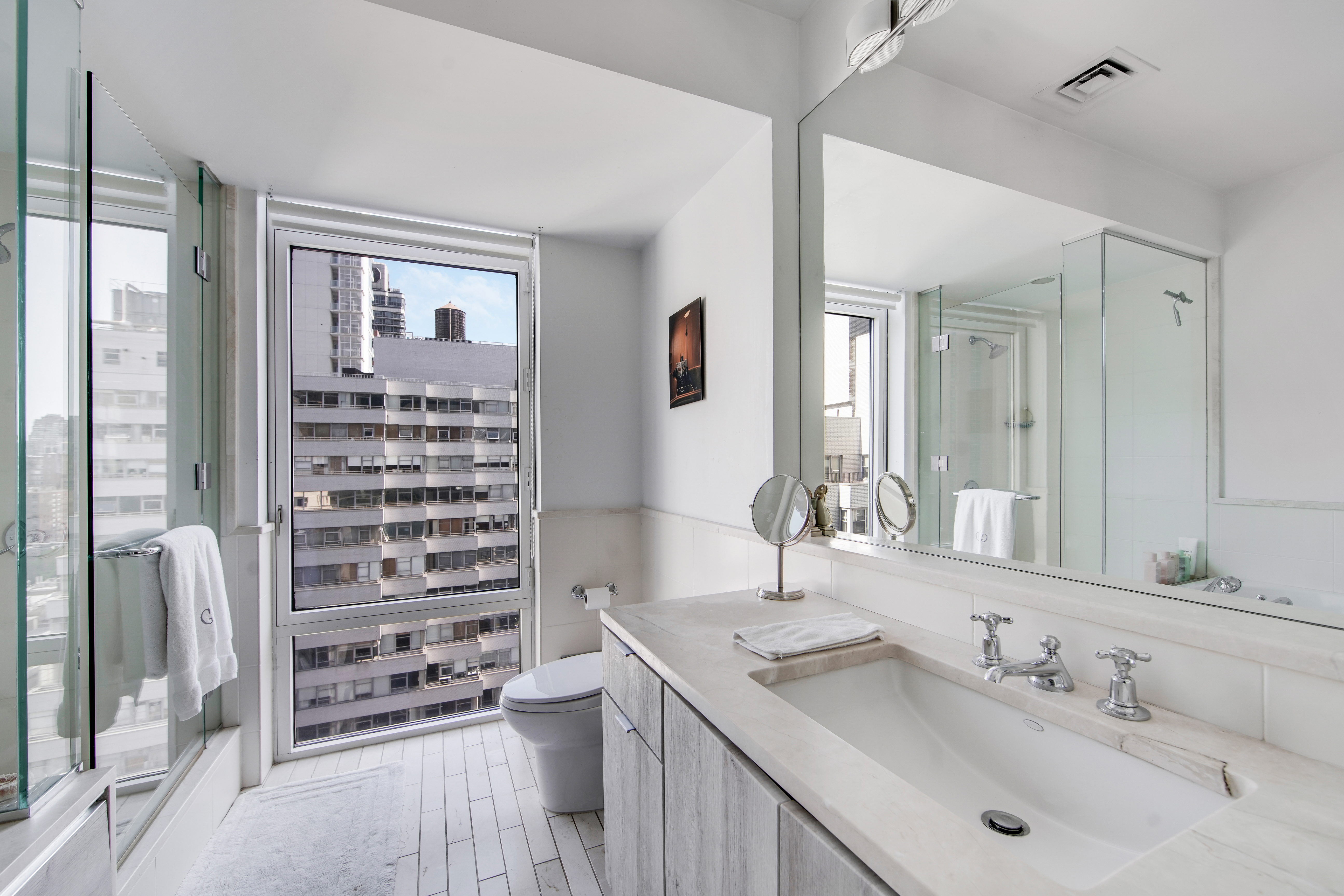 207 East 57th Street, Unit 20A Manhattan, NY 10022 - Photo 16 of 18 a bathroom with a sink double vanity and a shower