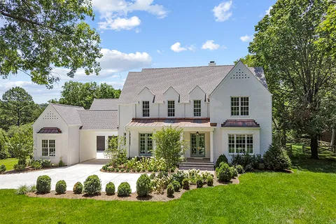 a front view of a house with a garden and yard
